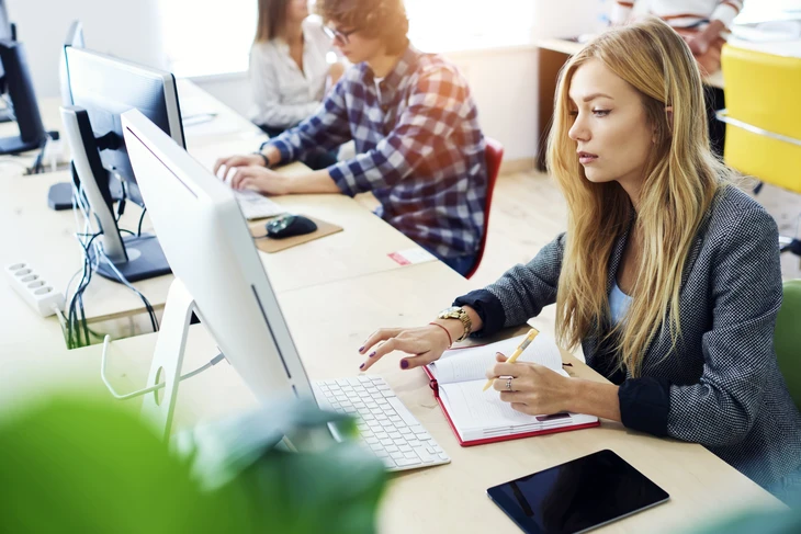 Espace de travail moderne avec développeur utilisant tablette tactile et écrans multiples