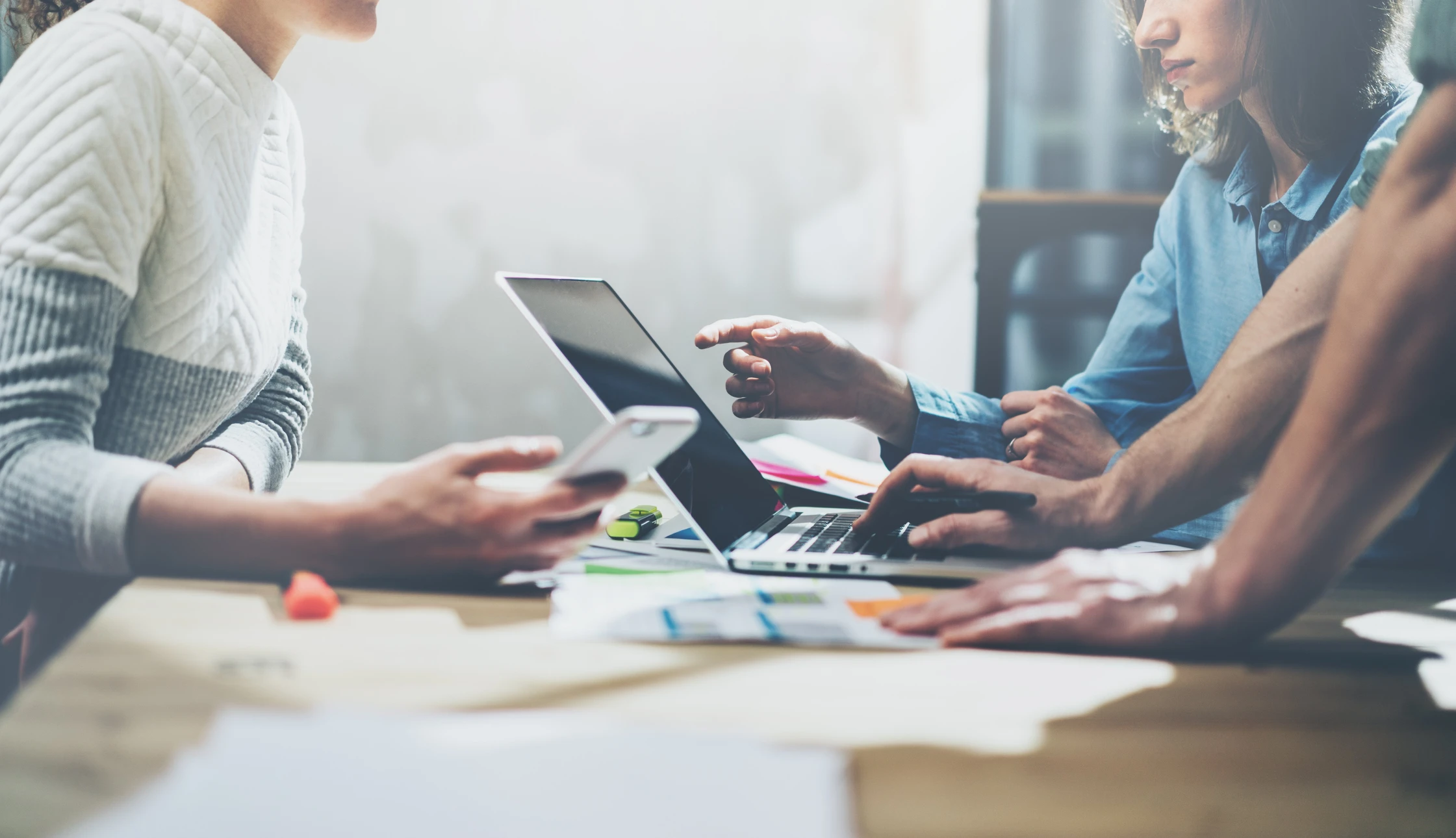 Réunion d'affaires dans un bureau moderne avec trois professionnels autour d'une table