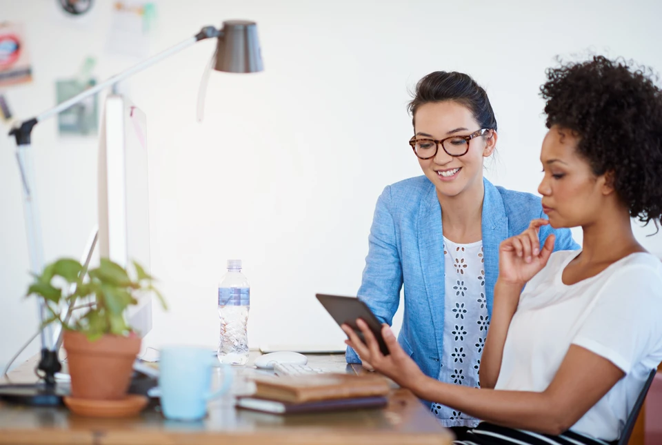 Personne travaillant sur ordinateur portable dans un environnement professionnel, consultant des graphiques et données analytiques à l'écran